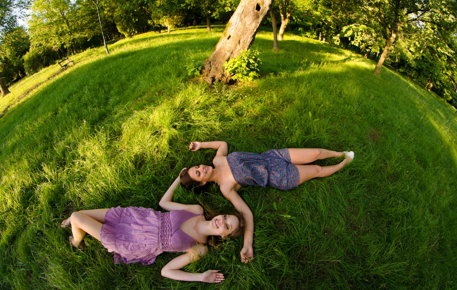 two women lying in shade on grass