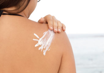 Sun cream on a woman's shoulder, horizontal
