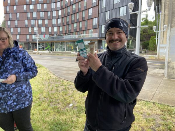 A participant in Portland shows off the sun protection products he picked up after his screening.