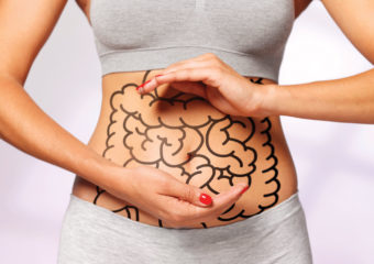 Picture of a woman showing her belly. She has a drawing on it. Skin Cancer Gut